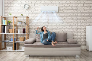 Person staying cool in the home with their AC. Apex Air, serving Portland OR & Vancouver explains how to stay in the summer.