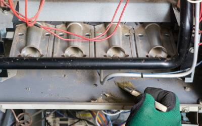 HVAC technician cleans burners, part of furnace repair service in portland or